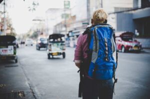 A boy carry a backpack on a street